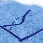 Illustration av ett kurvdiagram på en bakgrund bestående av en suddig karta.